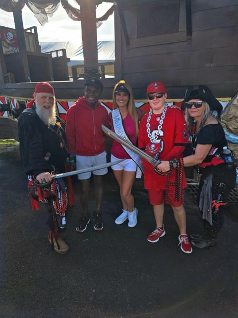 Kellie Lightbourn in her sash with costumed guests at an outdoor community festival