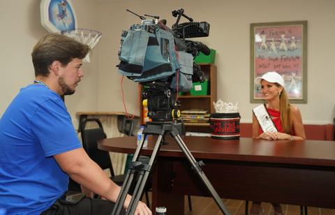Kellie Lightbourn in her sash and crown during a television interview