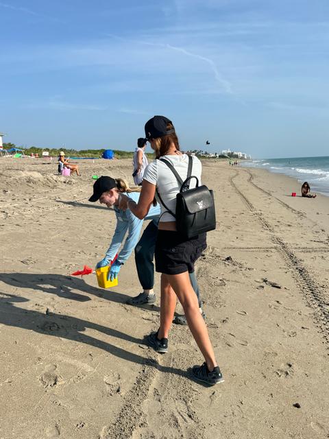 Kellie Lightbourn walking the beach with a conservation worker