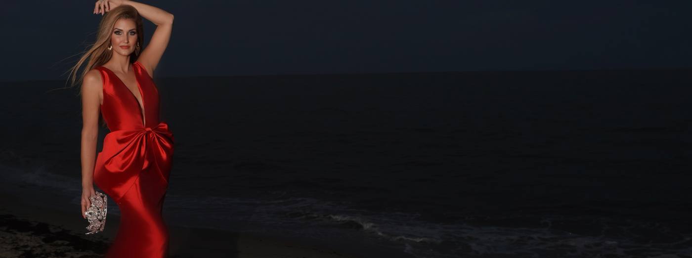 Kellie Lightbourn, Mrs. Universe® 2026, in a red bow gown on the beach at night