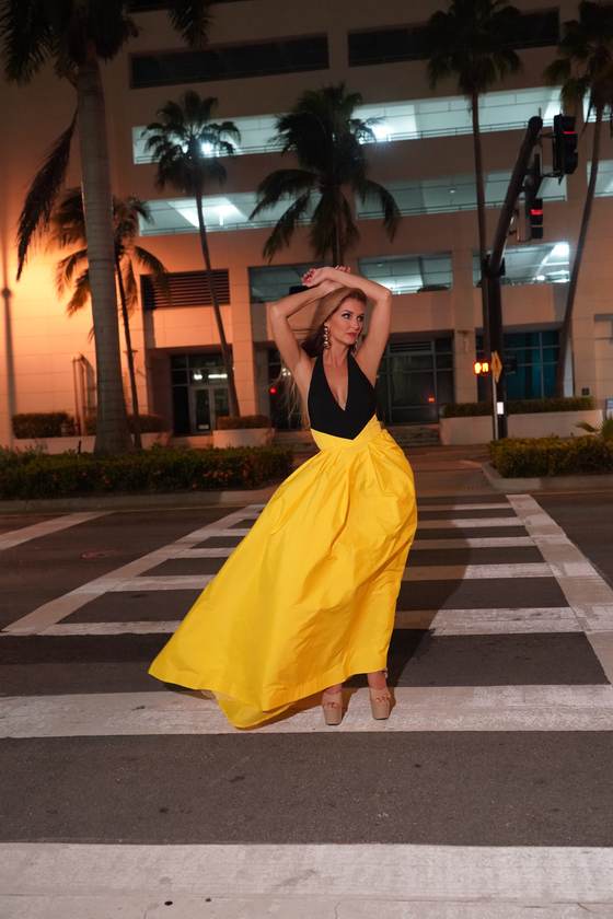 Kellie Lightbourn, Mrs. Universe® 2026, in a yellow gown on a city crosswalk at night